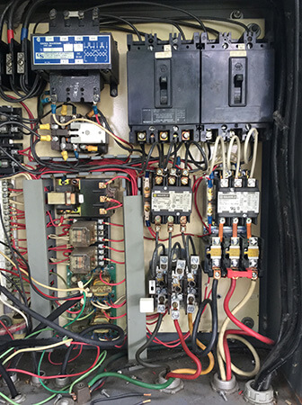 Commercial electrical control panel with breakers and contactors serviced by Tritan