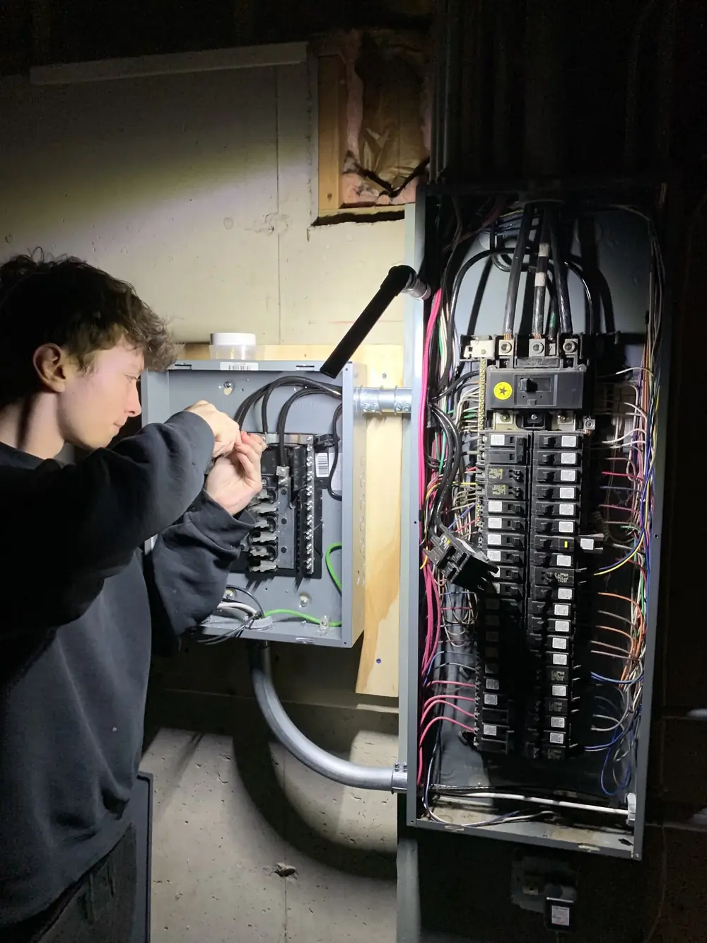 Tritan Services electrician troubleshooting an open electrical panel in a Naperville home