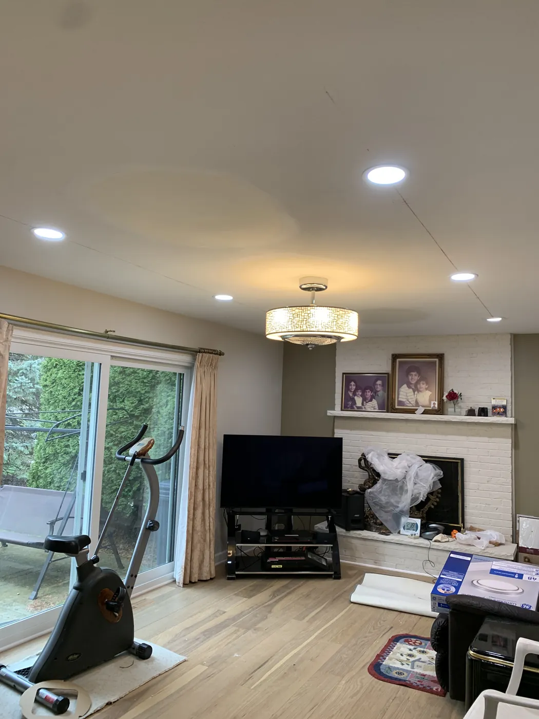 Recessed lighting and a ceiling fixture in a customer home living room