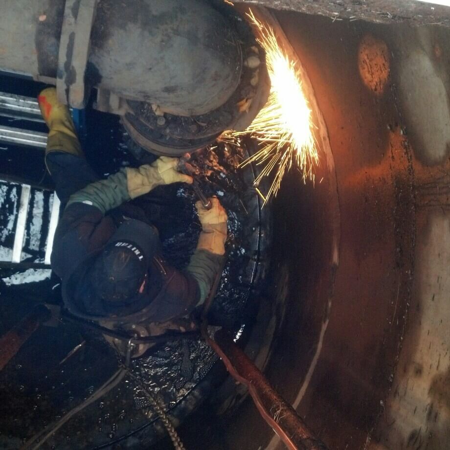 Tritan plumber welding a pipe repair with sparks flying