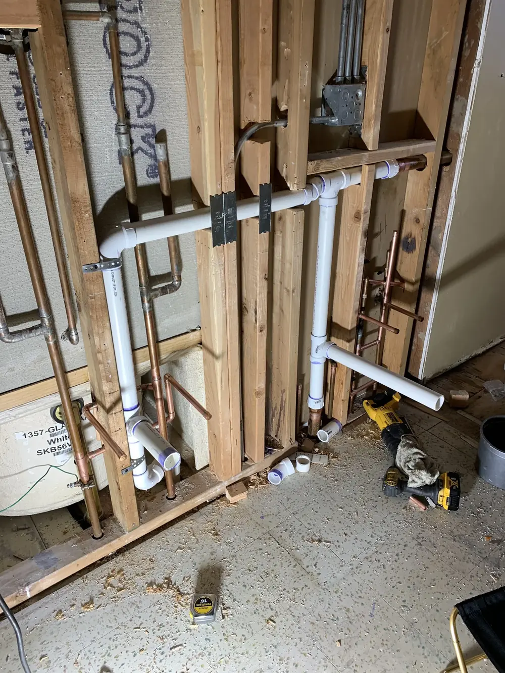 Plumbing rough-in with multiple supply and waste lines exposed during a Naperville home remodel by Tritan Services